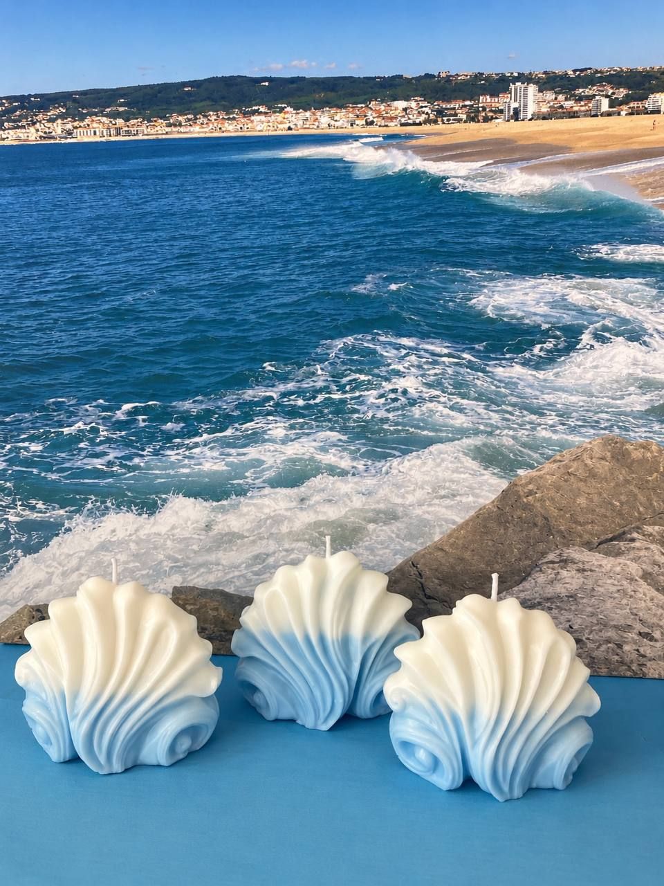 Velas em forma de onda na areia junto ao mar